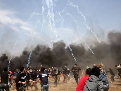 Manifestantes palestinos huyen del gas lacrimógeno disparado por las fuerzas de seguridad israelíes cerca de la ciudad de Khan Yunis, en la franja de Gaza.