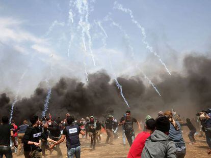 Manifestantes palestinos huyen del gas lacrimógeno disparado por las fuerzas de seguridad israelíes cerca de la ciudad de Khan Yunis, en la franja de Gaza.