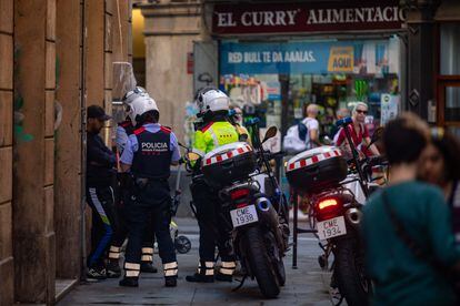 Agentes de los Mossos de Esquadra piden la documentación a una persona en la calle Riera Baixa esquina cona la calle Hospital en el barrio de El Raval de Barcelona.