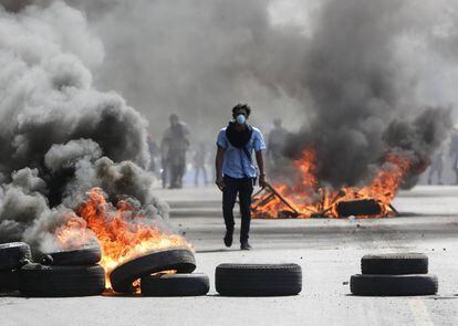 Un manifestante camina entre barricadas en Managua.