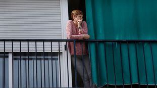 Una mujer en el balcón de su casa, durante el confinamiento en Terrassa (Barcelona).  En vídeo, el mensaje de "nietos adoptivos" a sus abuelos.