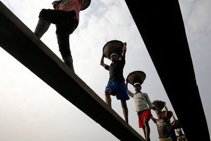 Un grupo de trabajadores de Bangladés desembarcan carbón cerca de Daca, capital de Bangladés.