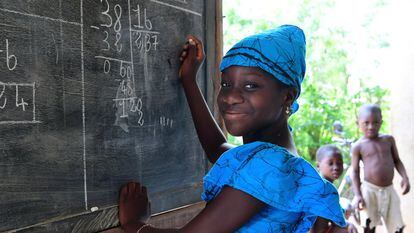 Fatimata Bagayogo (11 años) estudia en casa durante la pandemia, en Odienné, Costa de Marfil. Como las escuelas están cerradas, ella asiste a clases por televisión y practica matemáticas en una pizarra.