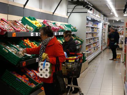 Varias personas hacen la compra en un supermercado en Madrid.