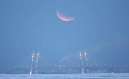 La superluna se aprecia sobre un puente de San Petersburgo (Rusia).