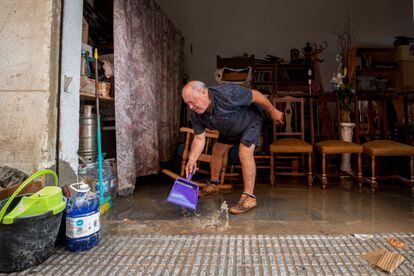 Un vecino del barrio de San Ginés de Cartagena (Murcia) retira el agua de su garaje, este martes.