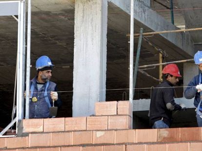 Tres alba&ntilde;iles trabajan en la construcci&oacute;n de una vivienda