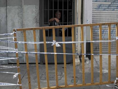 Una funcionaria del Ministerio de Salud conversa el pasado 5 de julio con un hombre que está bajo medidas sanitarias junto a otras 50 personas en un recinto de alquileres de habitaciones intervenido por las autoridades, en San José (Costa Rica), donde el día antes falleció una persona por Covid-19.