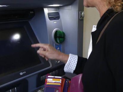 Una mujer retira dinero de un cajero automático, en Terrassa (Cataluña).