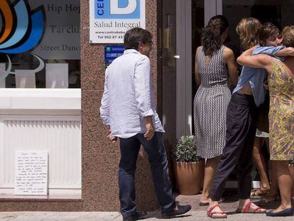 Familares de Vicente Pérez, uno de los fallecidos en un accidente de tráfico en la India, se abrazan en la puerta del centro que regentaba en Ronda.
