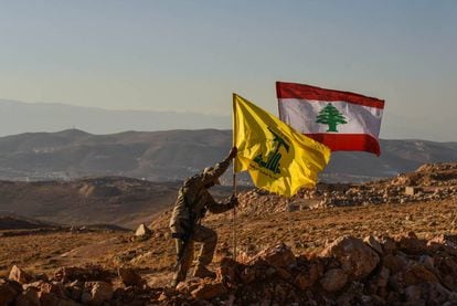 Un miliciano de Hezbol&aacute; planta las banderas libanesa y de la milicia tras expulsar a Al Nusra de los arreales de la localidad libanesa de Arsal