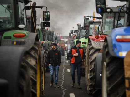 Dos agricultores entre tractores que bloquean la autopista A4 en Jossigny, al este de París, el 30 de enero.