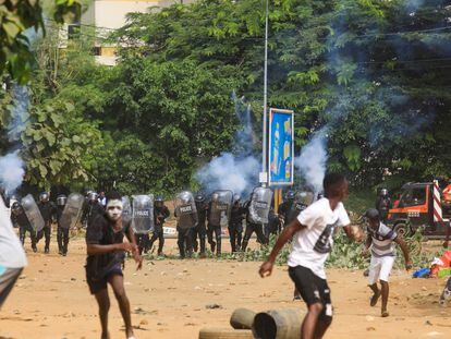 Manifestantes protestando contra el presidente Alassane Outtara huyen del gas lacrimógeno en Abidjan, el pasado 13 de agosto.