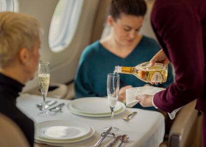 The cabin crew serves travelers a few glasses of Ruinart champagne.