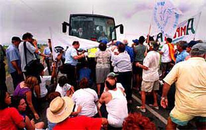Un grupo de manifestantes rodeando el autobús donde viajaba Felip Puig, ayer, en el delta del Ebro.