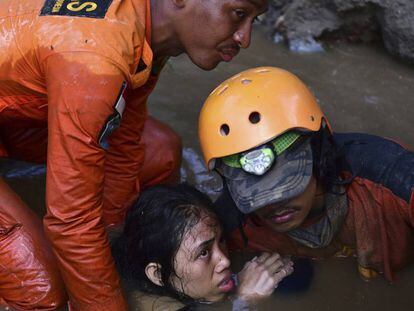 FOTO: Un equipo de búsqueda y rescate ayudan a una joven atrapada en su vivienda. / VÍDEO: La devastación del tsunami, a vista de dron