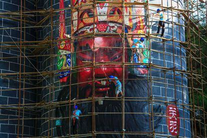 Varios trabajadores pintan máscaras de la ópera Dixi en Anshun (China). Tres máscaras de 13 metros de alto y 23 de ancho promocionan el festival de máscaras de ópera Dixi.