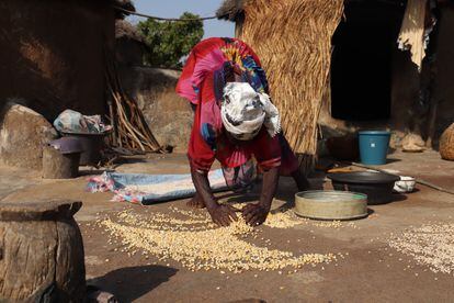 Una mujer rescata cereales de los restos que nadie quiere comprar en el mercado local de Gushegu, al norte de Ghana.