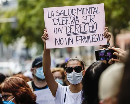 Una mujer muestra una pancarta donde se lee "La salud mental debería ser un derecho no un privilegio", en una manifestación por la salud mental, el pasado 10 de octubre.