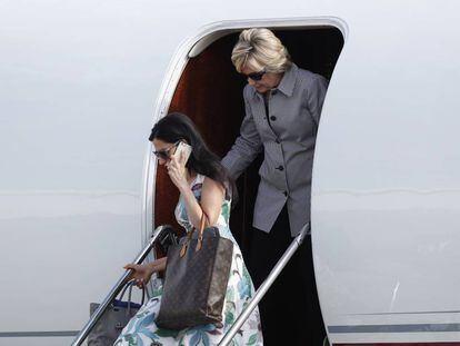 Clinton desciende del avi&oacute;n de campa&ntilde;a junto a su asistente Huma Abedin.