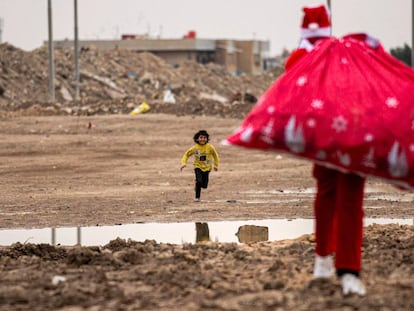 Un niño corre hacia Papá Noel, en un barrio pobre cerca del centro de la ciudad de Basora, en el sur de Irak, el 24 de diciembre.