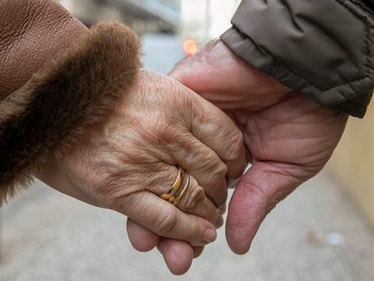 Una pareja camina de la mano por una calle de Zaragoza el día de San Valentín.