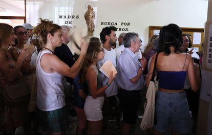 Electores se abanican con las papeletas ante el calor esta mañana en el colegio electoral de Cristo Rey, Madrid. 
