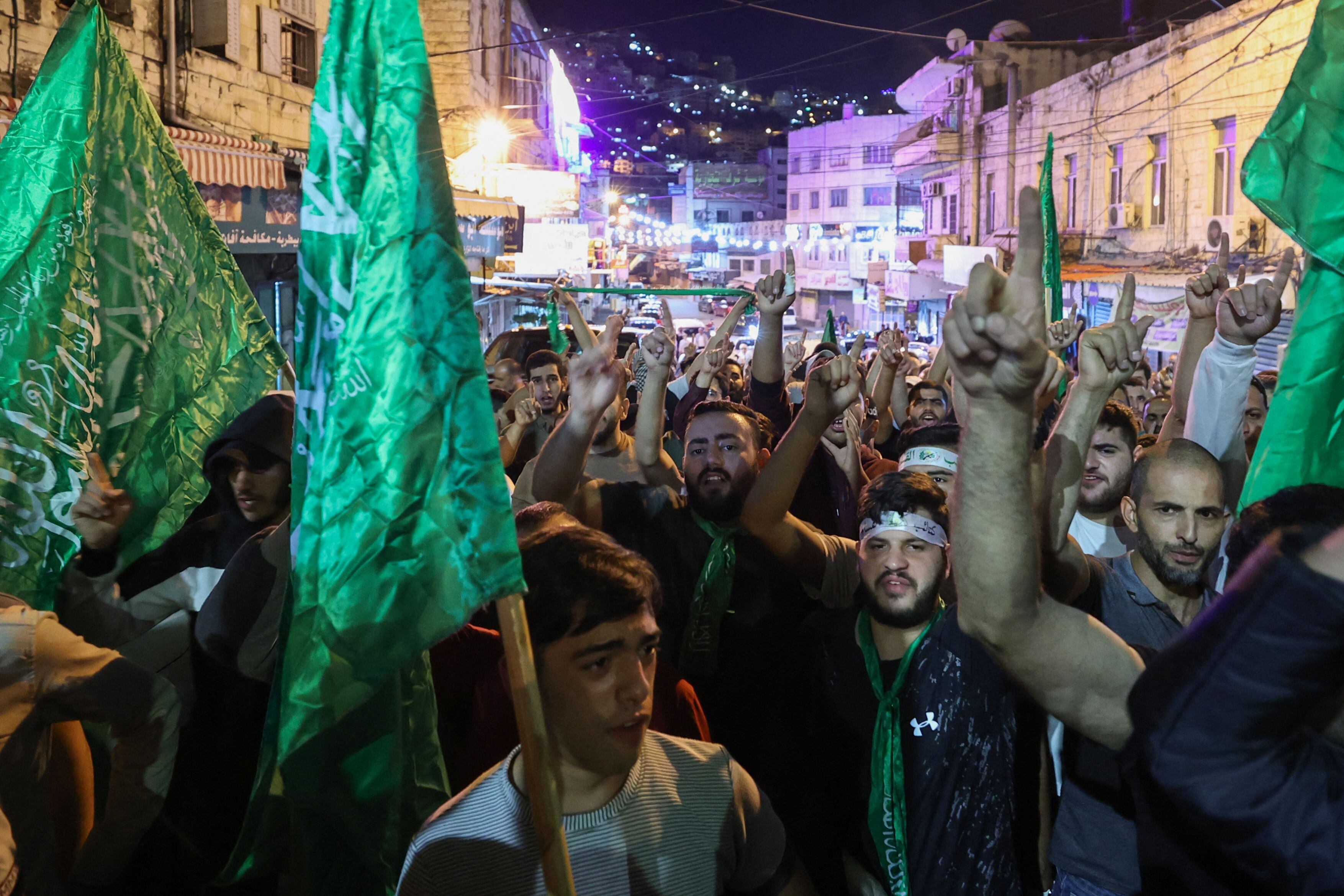 Manifestantes palestinos llevan banderas de Hamás en Nablús, en Cisjordania.