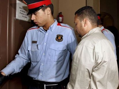 Un agente de los Mossos conduce a un detenido en los juzgados.