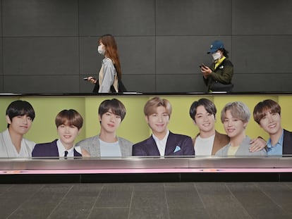 People walk past a commercial poster showing K-pop group BTS members at a subway station in Seoul on October 12, 2020. (Photo by Jung Yeon-je / AFP) (Photo by JUNG YEON-JE/AFP via Getty Images)