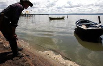 Un hombre observa el agua contaminada de la orilla del lago Ypacaraí en la localidad de Areguá (Paraguay). EFE/Archivo