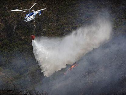 Un helicóptero descarga agua sobre el incendio de la Serra de l&#39;Almirant.