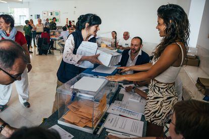 Una cartera entrega el voto por correo en una mesa del Centro Galego de Arte Contemporaneo de Galicia, en Santiago de Compostela.