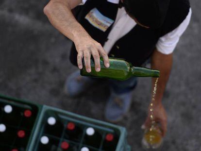 Un hombre escancia sidra en una feria en Gijón. En vídeo, Asturias pierde la exclusividad de la botella sidra.
