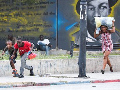 Varias personas corren para protegerse de un tiroteo cerca del Palacio Nacional en Puerto Príncipe, el pasado día 21.