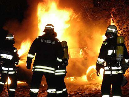 Los bomberos apagan un coche incendiado en Berlín a primeras horas del pasado día 9.