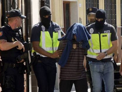 Efectivos de la Policía Nacional traslada a una persona detenida en Melilla.