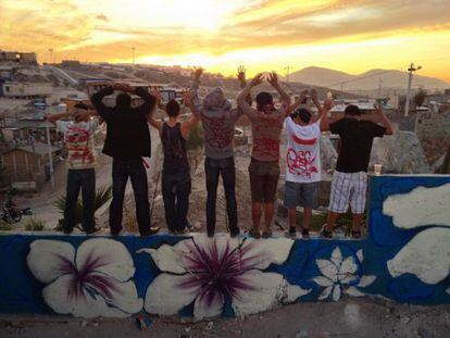 Algunos de los chicos que ayudaron a grafitear posan viendo el atardecer sobre Tijuana.
