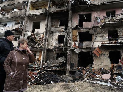 Vecinos miran el edificio de diez plantas atacado en la madrugada del viernes en Kiev con el resultado, según la Policía, de cinco heridos.