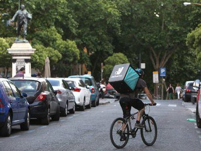 Un repartidor-mensajero de la empresa Deliveroo, en bicicleta por el centro de Madrid