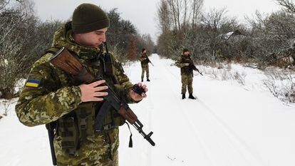 Varios soldados ucranios patrullan por la frontera entre Ucrania y Bielorrusia, cerca de Pripriat, donde se encuentra los restos de la central de Chernóbil.