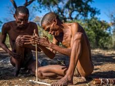 Un hombre enciende una hoguera en el museo viviente de los ju/’hoansi, en Grashoek, Namibia, en mayo de 2016.