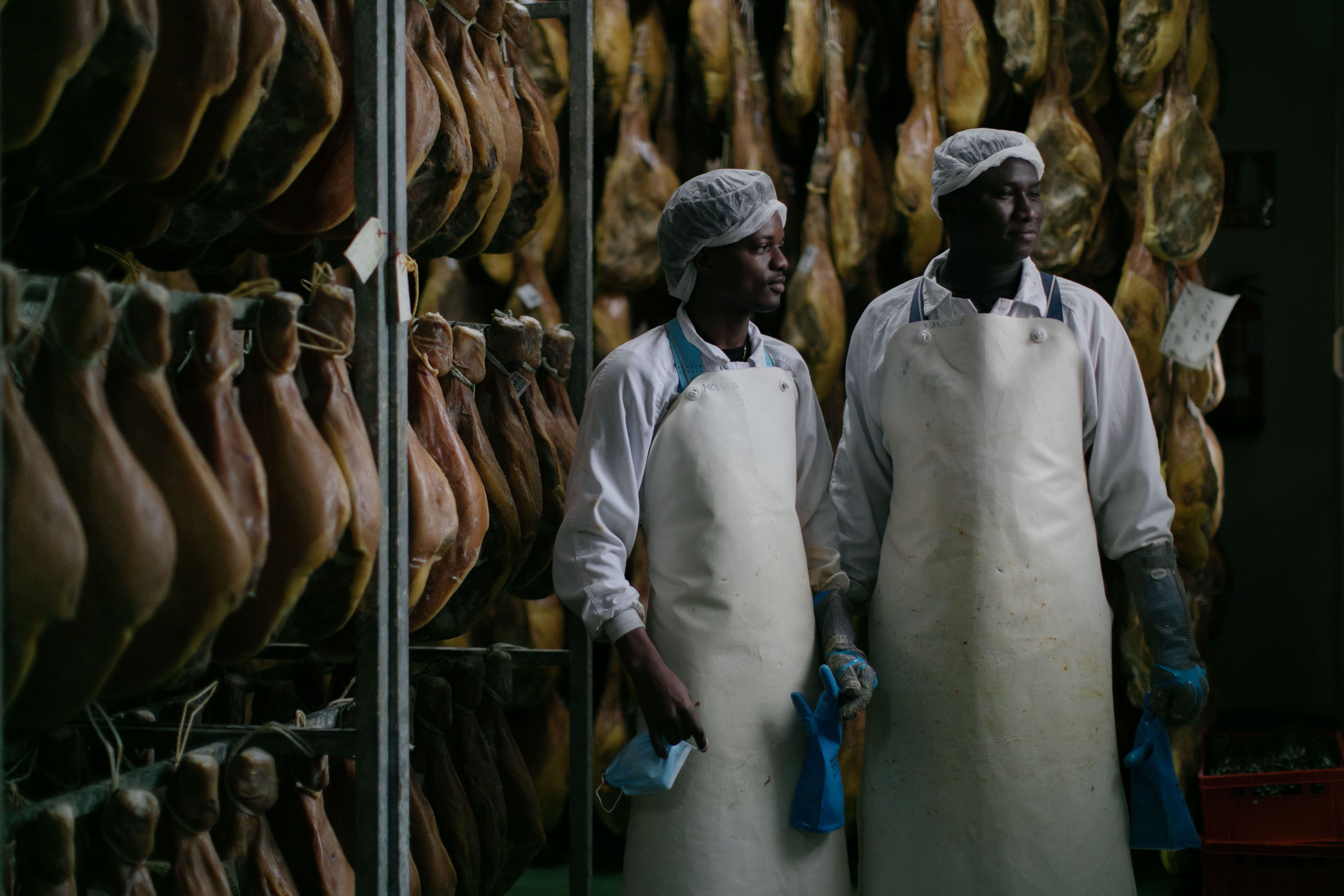 Los malienses Moussa K. y Madiogue D., en La Hoguera, la fábrica de productos del cerdo en la que trabajan, en San Pedro Manrique (Soria).
