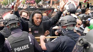 A protester clashes with police after a grand jury considering the March killing of Breonna Taylor, a Black medical worker, in her home in Louisville, Kentucky, voted to indict one of three white police officers for wanton endangerment, in Louisville, Kentucky, U.S. September 23, 2020. REUTERS/Bryan Woolston