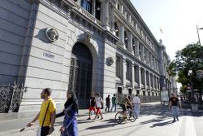Varios transeúntes caminan por la madrileña calle de Alcalá, junto al edificio del Banco de España.