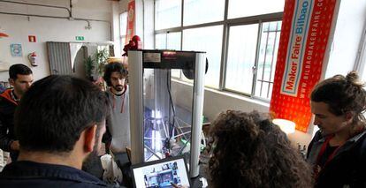 Varios jóvenes interactúan con una impresora 3D fabricada y configurada por ellos en la edición de 2017.