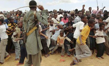 Un miembro de Al Shabaab trata de controlar a manifestantes contra la incursión keniana a las afueras de Mogadiscio.