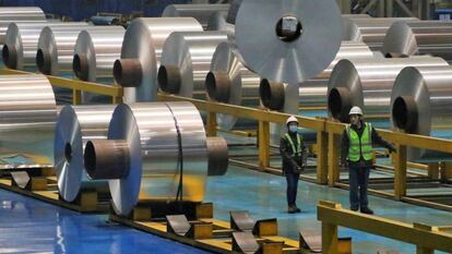 Dos trabajadores en una fábrica de aluminio.
