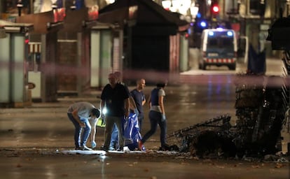 Agentes de policía forense buscan pistas cerca de donde la furgoneta de atentado se estrelló.