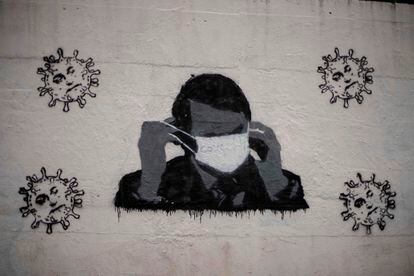 Un grafiti en una calle de Río de Janeiro del presidente Jair Bolsonaro con una mascarilla.
